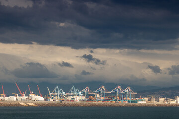 grues sur le port de Naples sous un ciel orageux