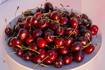Obraz na płótnie Canvas Ripe juicy large fragrant cherries on a plate.