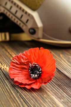 Poppy Flower And Helmet On Wooden Background. Remembrance Day