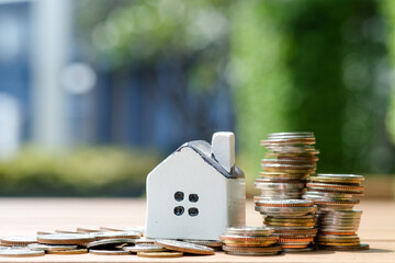 Mini house and stack of coins. Concept of Investment property.	
