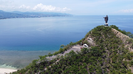 Aerial view of Timorese landmark of Cristo Rei, Jesus Christ, statue, ocean and coastline of Dili, Timor Leste in Southeast Asia