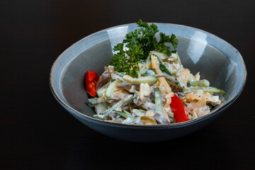 Closeup of salad with meat, vegetables and mayo on a black background