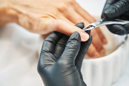 Manicurist Nipping Away Skin From Nail With Cuticle Cutter