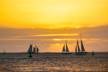Sailing boats silhouettes at sunset against wonderful ocean sunset.