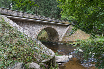 Fototapeta na wymiar Bridge gate Zemska brana, river Divoka Orlice, Czech republic Eagle mountains (Orlicke hory) during summer time.