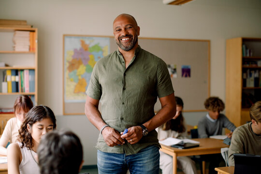Portrait of male teacher standing in classroom