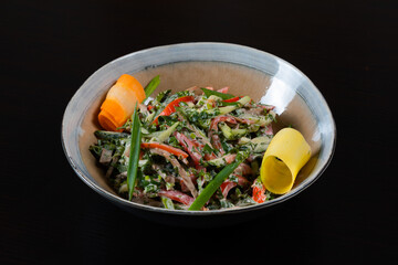 Salad with vegetables, chicken and mayo on a black background
