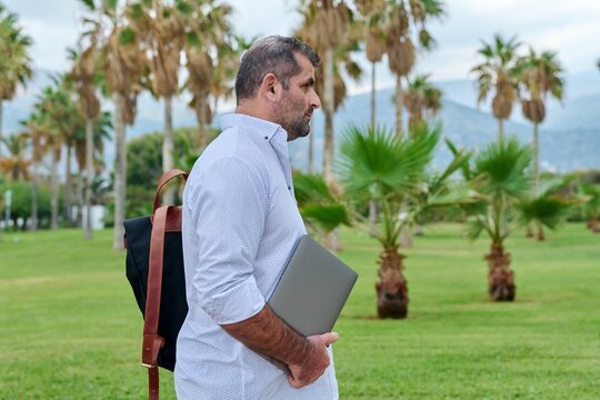 Portrait Of Serious Confident Mature Man With Laptop Outdoors