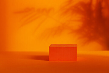 Orange podium with shadows leaves on orange background. Concept scene stage showcase for product,...