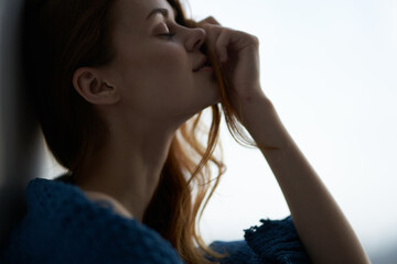 woman sitting on the windowsill with a blue plaid morning