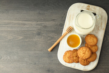 Milk, honey and pumpkin cookies on gray wooden table