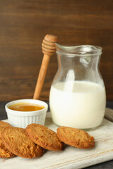 Milk, honey and pumpkin cookies against wooden background
