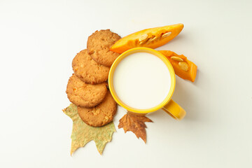 Milk and pumpkin cookies on white background