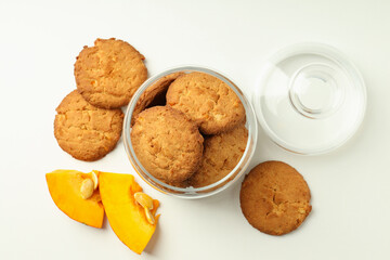 Jar with pumpkin cookies on white background