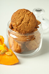 Jar with pumpkin cookies on white background