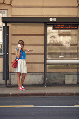 Young caucasian woman waiting for a public transportation on a station.