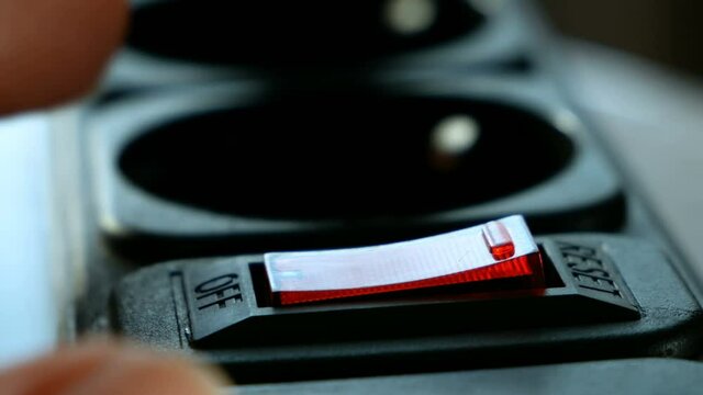 human figer press and off red lighting outlet switch on black Electric Extension Cord, closeup,