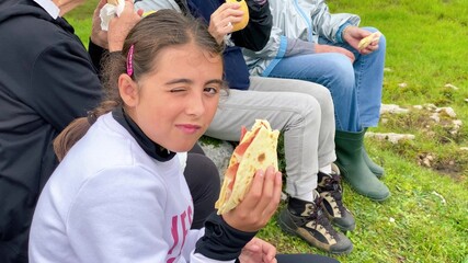 Family relaxing and eating lunch after a mountain trail excursion