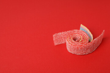 Gummy candy on red background, space for text