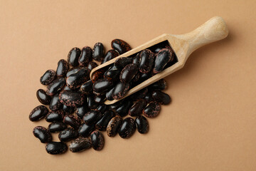 Scoop with black beans on beige background