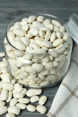 Jar with white beans on gray wooden background