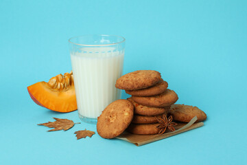 Milk and pumpkin cookies on blue background