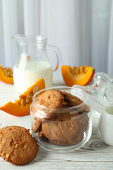 Concept of tasty food with pumpkin cookies on white wooden table