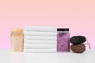 Bath towels and spa salt on white table