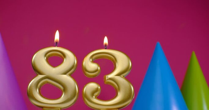 Burning birthday cake candle number 83. Happy Birthday background anniversary celebration concept. Birthday hat in the background