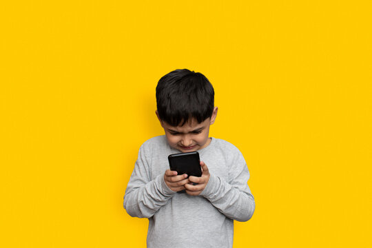 leisure, children, technology and people concept - smiling boy with smartphone  or playing game at home copy space