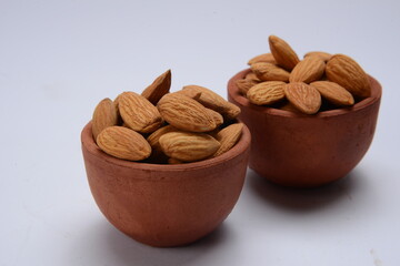 Fresh almonds in the wooden bowl, Organic almonds, almonds border white background, Almond nuts on a dark wooden background. Healthy snacks. Top view. Free space for text.
