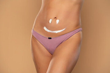 Pretty woman with smile drawn on her belly