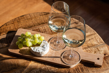 White wine, grapes and blue cheese on a wooden board