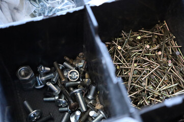 Fototapeta na wymiar a lot of nails and screws in boxes. tools for repair. men's business. building. hobby . Selective focus