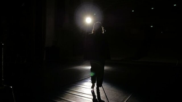 The girl singer goes on stage to perform a song.