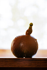 A black Crimean tomato with a strange growth, on a wooden table. Space for copy
