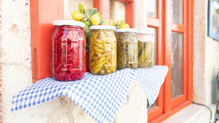 Jars of pickled vegetables in the garden. Marinated food.