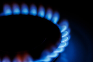 Close up blue flame of the gas burner of the kitchen stove in the dark