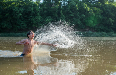Teenager splashes water in the river.