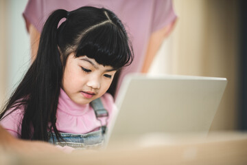 Asian children learning from home, homework learning with father and mother together in daughter family by laptop technology people, happy girl in online education lifestyle