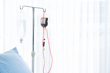 Closeup view of drip chamber for an intravenous infusion set in hospital for blood transfer in...