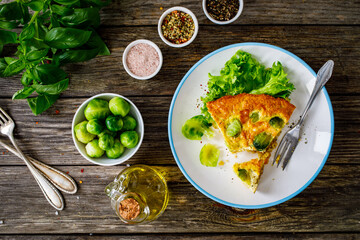 Millet quiche with brussels sprouts and ricotta on wooden table
