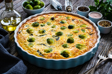 Millet quiche with brussels sprouts and ricotta on wooden table
