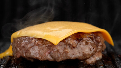 Beef patty for burger with cheddar cheese on grill. Cooking Tasty burger