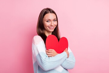 Photo portrait of curious girlfriend embracing heart sign red card smiling isolated on pastel pink color background