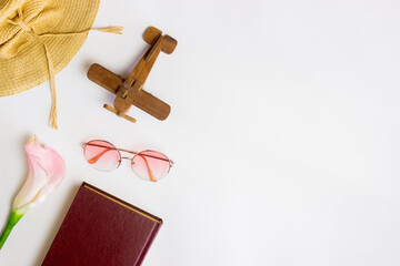 Travel concept with hat, leaves. sun glasses and camera over the whtie table. 
