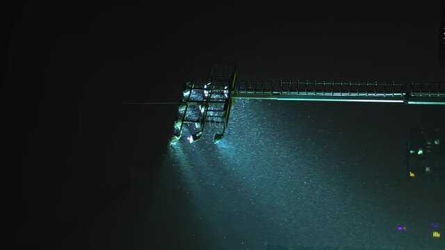 Rack focus of stadium lights in front of a dark blue sky. Light Stadium at night, baseball and hockey. There is a rain or snow. military security lighting towers, patrol in prison. vertical video,