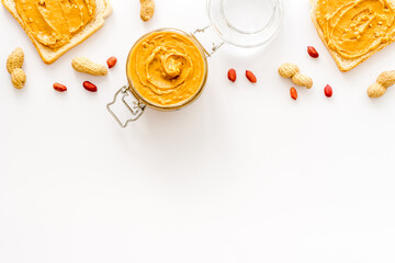Obraz na płótnie Canvas Peanut butter sandwiches and creamy butter in glass jar, top view