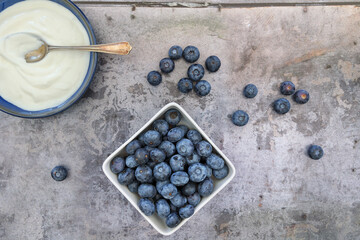 A top view, flatlay, overhead view of blueberries on a blue wooden textured background with space for text, 