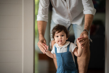 father help children baby to walk, childhood family people with little cute toddler child son, happy learning in first step with support together from father at home